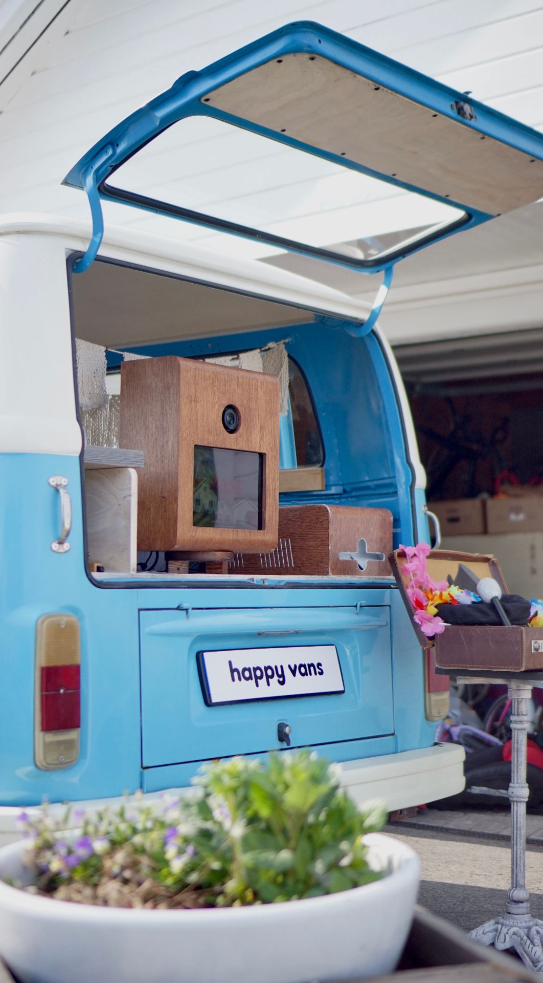 HappySmiles VW-buss sett bakfra med happy vans-skilt og photobooth inne i bakluken